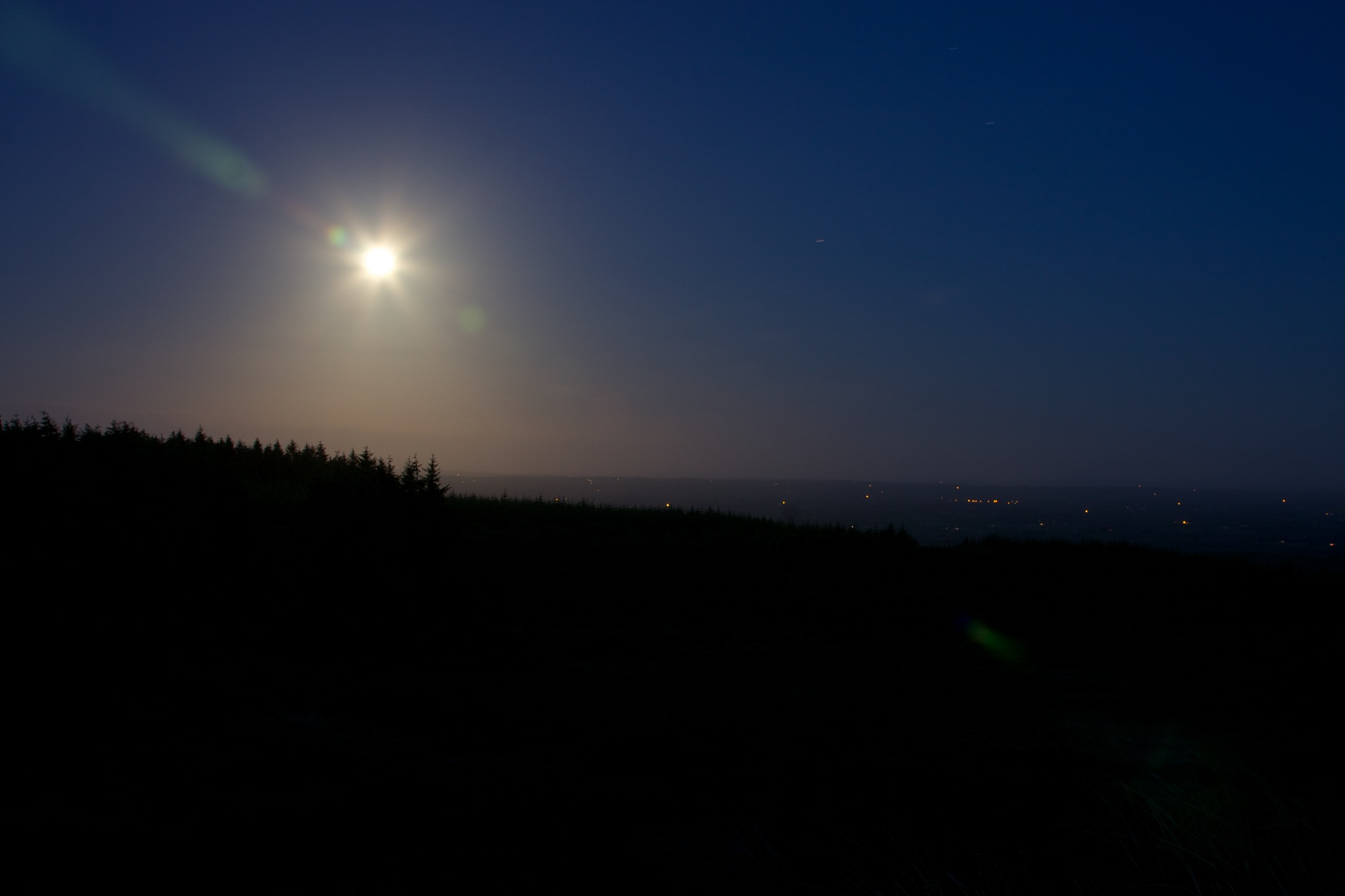 Bright hazy glow of the moon with the lights Monaghan town in the distance