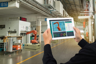 iot industry 4.0 concept,industrial engineer using software (augmented, virtual reality) in tablet to monitoring machine in real time.Smart factory use Automation robot arm in automotive manufacturing