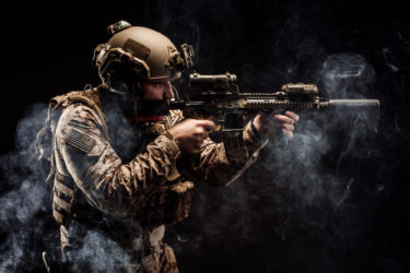 Special forces United States soldier or private military contractor holding rifle. Image on a black background. war, army, weapon, technology and people concept